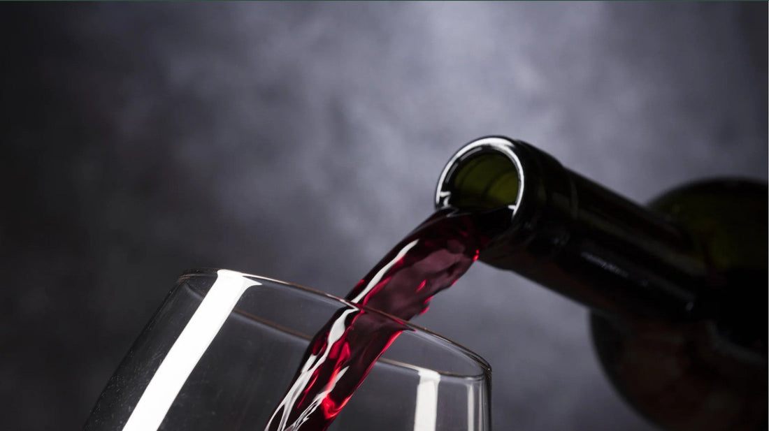 Vernatsch wird von einer Flasche in ein Weinglas eingeschenkt